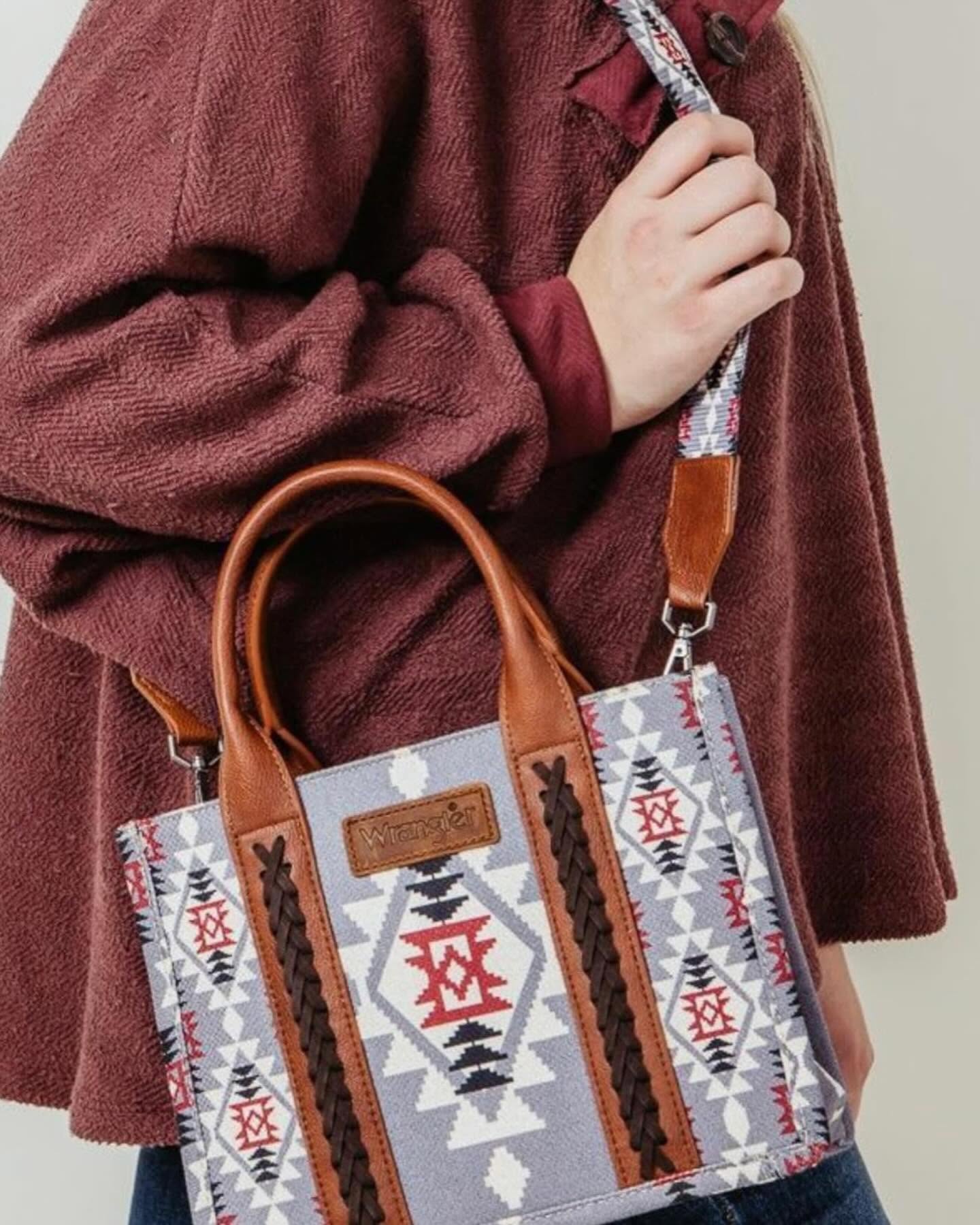 Model carrying a blue-gray western patterned tote with leather handles