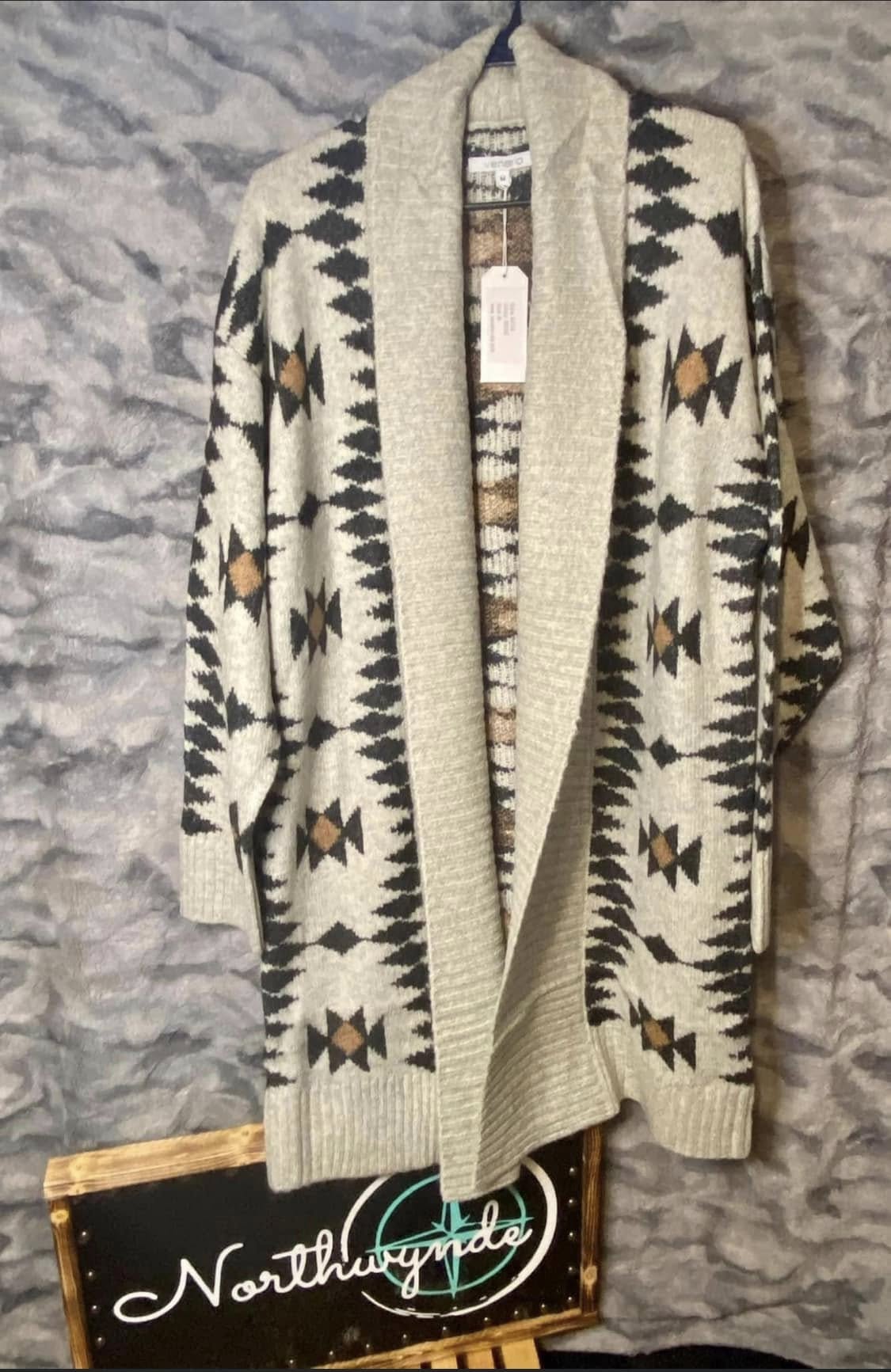 Cream and black western-pattern cardigan displayed above a Northwynde sign